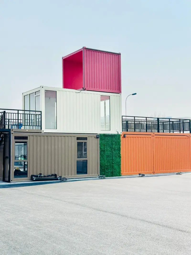 Stacked colorful modular boxes forming a two-story building on a paved lot