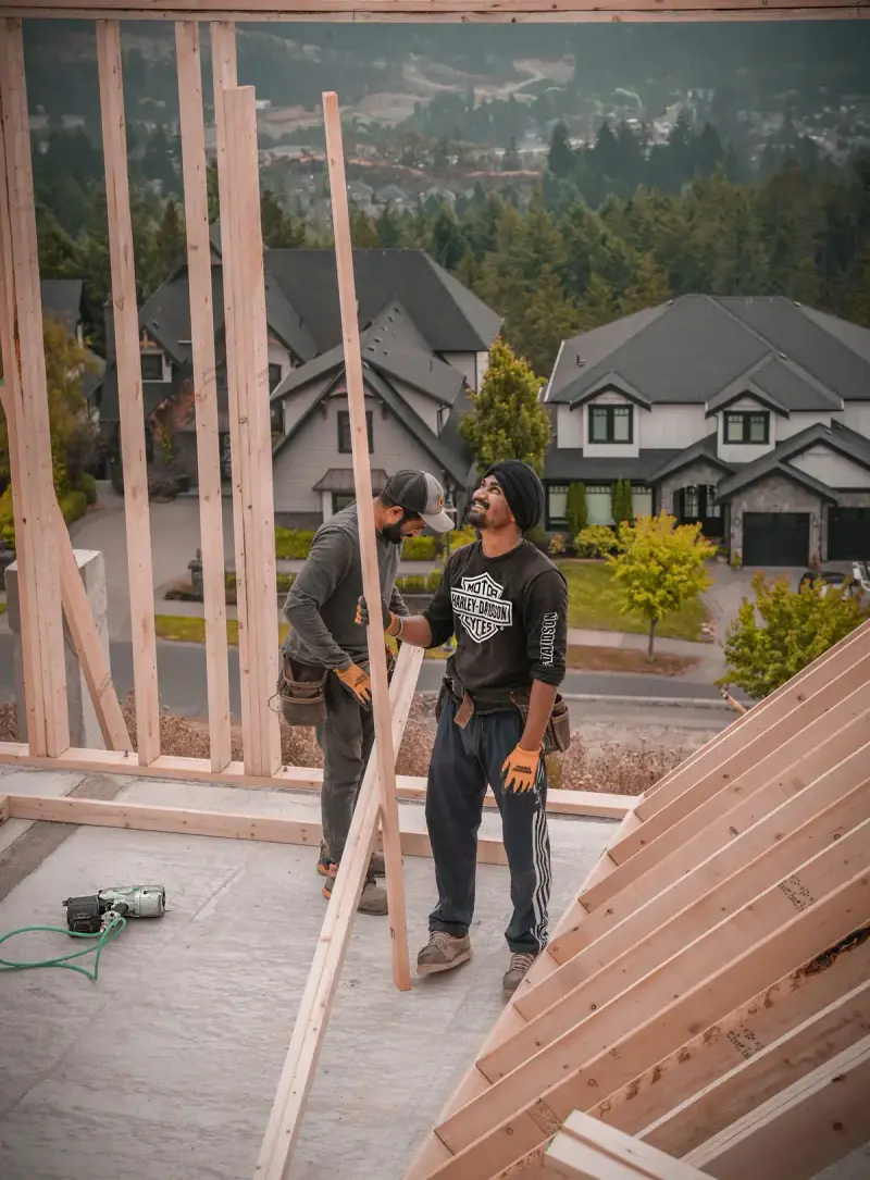 Two workers assembling a wooden wall frame for a house in Vancouver