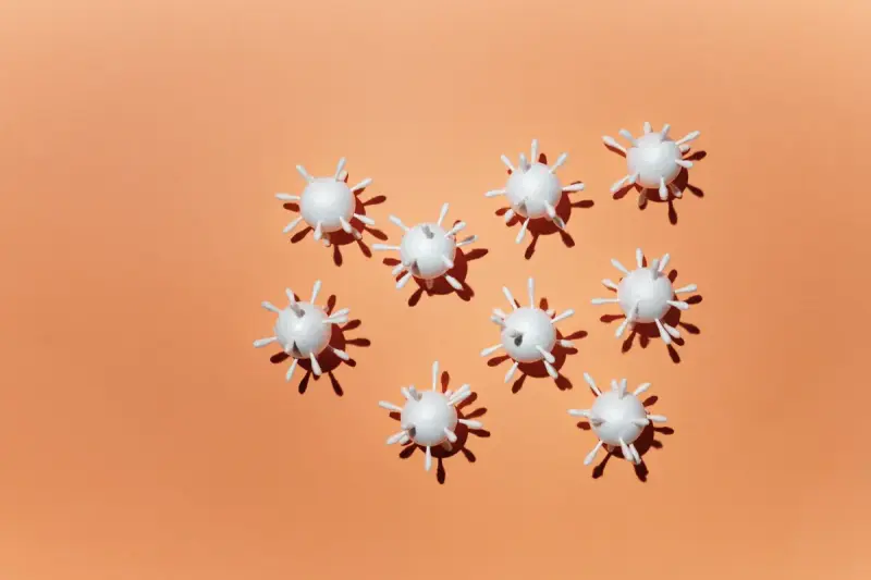 White scale models of a virus particle on a peach background