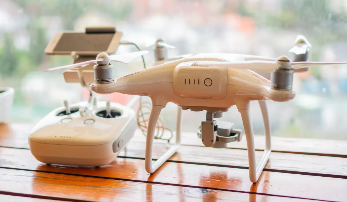 White quadcopter and its controller displayed on a table
