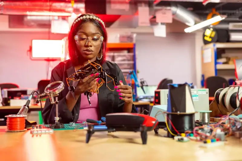 Woman working with drone electronics at a technical workbench