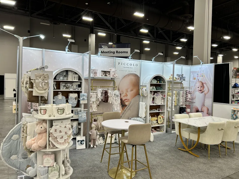 Piccolo Bambino booth by Purple Exhibits: soft white and cream inline booth for Piccolo Bambino, a Purple build like the booths we plan for Collective Shows
