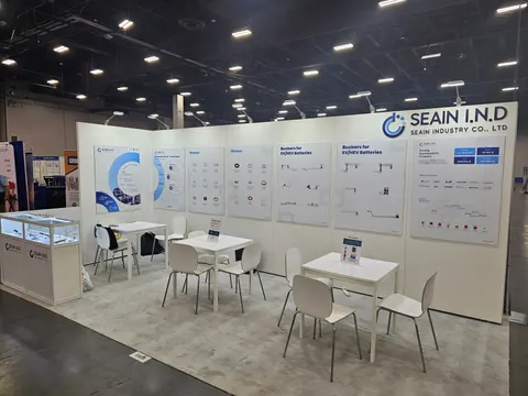 Seain Industry Co., Ltd trade show booth built by Purple Exhibits: Long white inline back wall for Seain Industry with blue-accented technical panels of washers and busbars for EV batteries, glass display counter, and wh