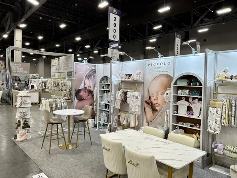 Piccolo Bambino booth by Purple Exhibits: alternate angle of the Piccolo Bambino inline booth showing arched white