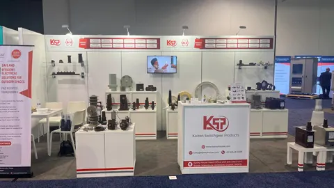 Kaizen Switchgear Products (KSP) trade show booth built by Purple Exhibits: White inline booth with red accents for KSP Kaizen Switchgear Products, shelved displays of electrical switchgear components, a TV screen and a