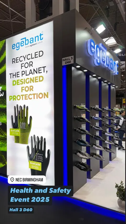 egebant trade show booth built by Purple Exhibits: Vertical social-style shot of the egebant booth at NEC Birmingham Health and Safety Event 2025 showing a recycled-gloves lightbox and a dark wall of mounted gloves with