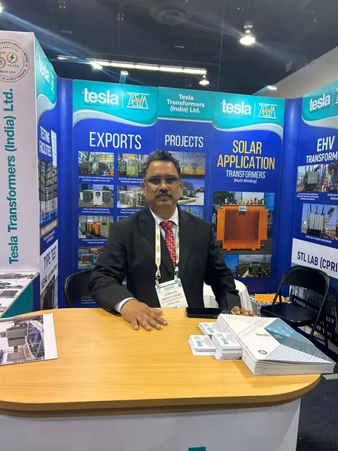 Tesla Transformers (India) Ltd. booth by Purple Exhibits: staff member seated at a wood-topped counter in a blue-graphic, the kind of booth we build for EV Charging Summit & Expo