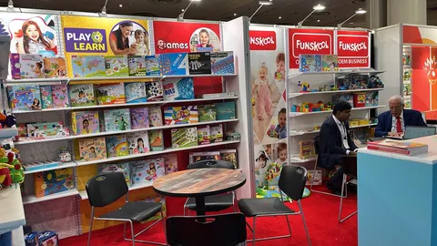 Funskool booth by Purple Exhibits: second angle of the Funskool booth showing white shelf walls of boxed toys and books