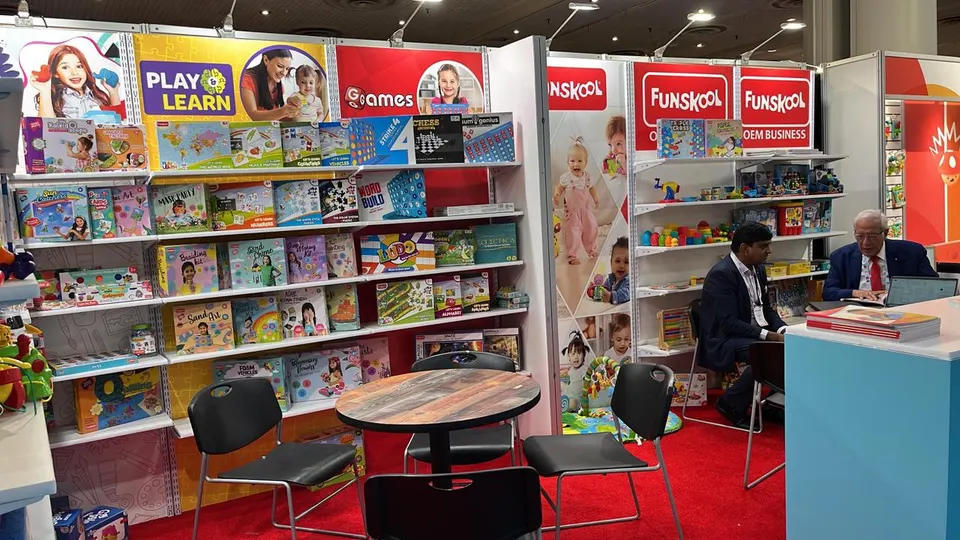 Funskool booth by Purple Exhibits: second angle of the Funskool booth showing white shelf walls of boxed toys and books, like the booths we plan for ECRM Sessions