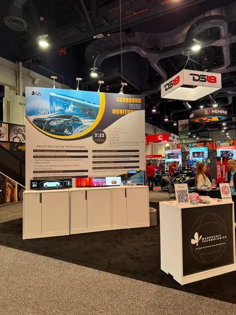 Moorechip Technologies trade show booth built by Purple Exhibits: Inline booth for Moorechip Technologies at an automotive aftermarket show with a tall white back wall graphic promoting a 3D 360 surround view monitoring