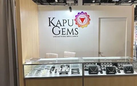 Kapu Gems booth by Purple Exhibits: kapu Gems inline booth with a white back wall and colourful logo