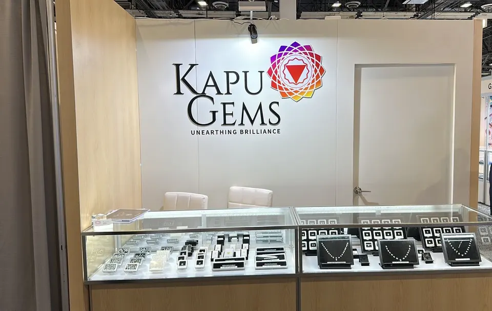 Kapu Gems booth by Purple Exhibits: kapu Gems inline booth with a white back wall and colourful logo, a reference for planning a JIS booth