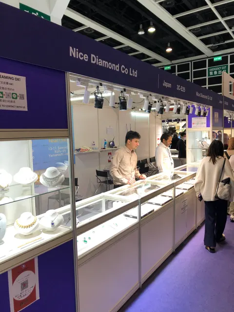 Nice Diamond Co Ltd booth by Purple Exhibits: angled view of a purple-fascia shell-scheme jewelry booth