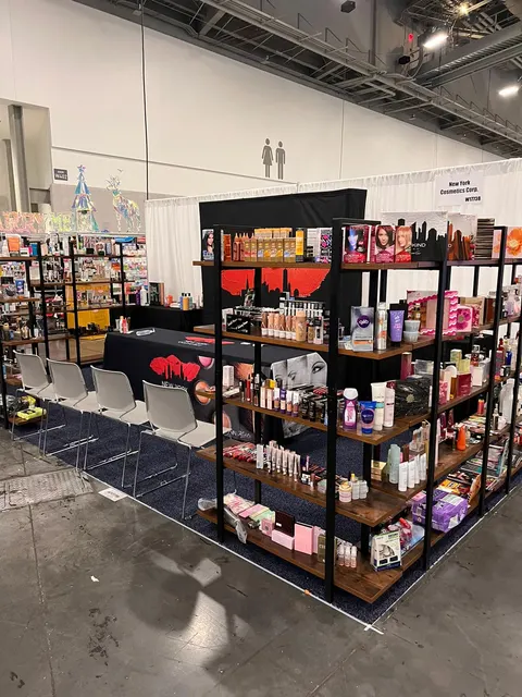 New York Cosmetics Corp. trade show booth built by Purple Exhibits: Corner inline booth for New York Cosmetics with black metal and wood open shelving units packed with cosmetics and skincare products, a black draped tab
