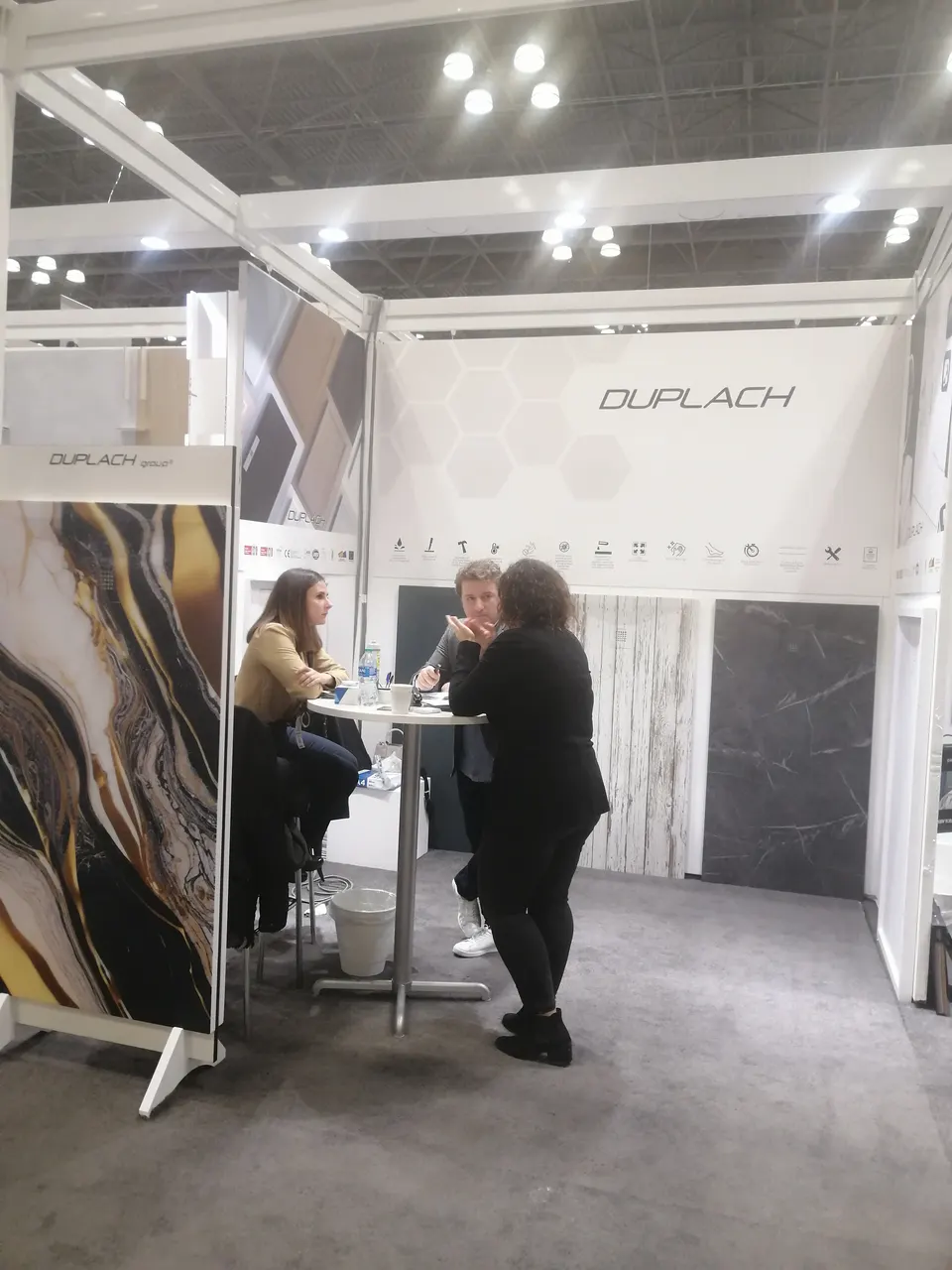 Duplach booth by Purple Exhibits: white Duplach booth showing large-format porcelain slabs in gold-veined marble, an example for IBS exhibitors in Las Vegas