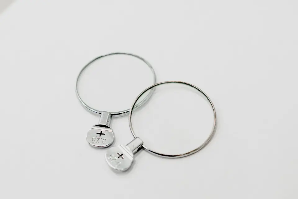 Two round metal-rimmed trial lenses on a clean white surface