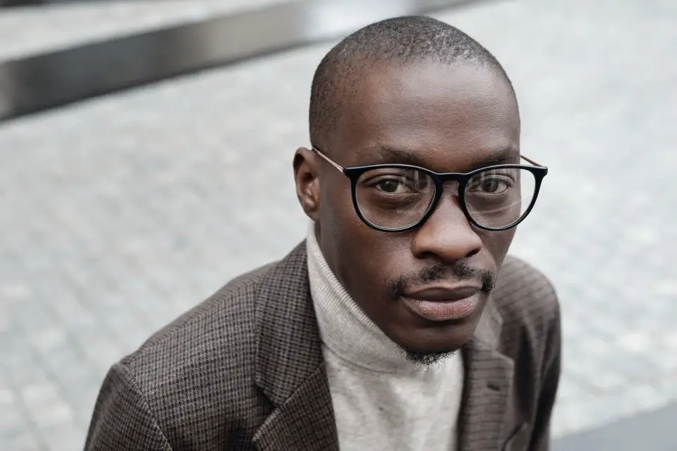 Man in black panto eyeglasses and a tweed blazer, street portrait