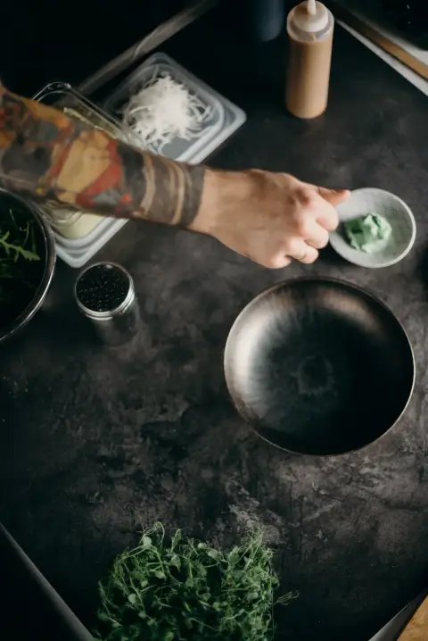 Chef preparing fresh greens and ingredients in a kitchen