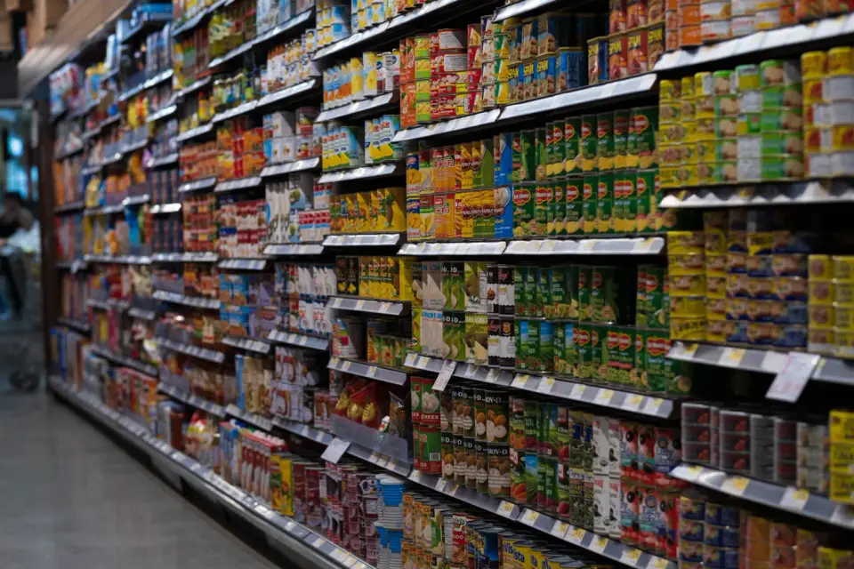 Supermarket aisle with shelves stocked with colorful canned and packaged foods