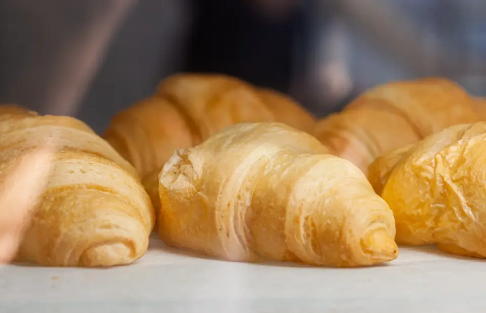 Fresh golden croissants on a bakery counter