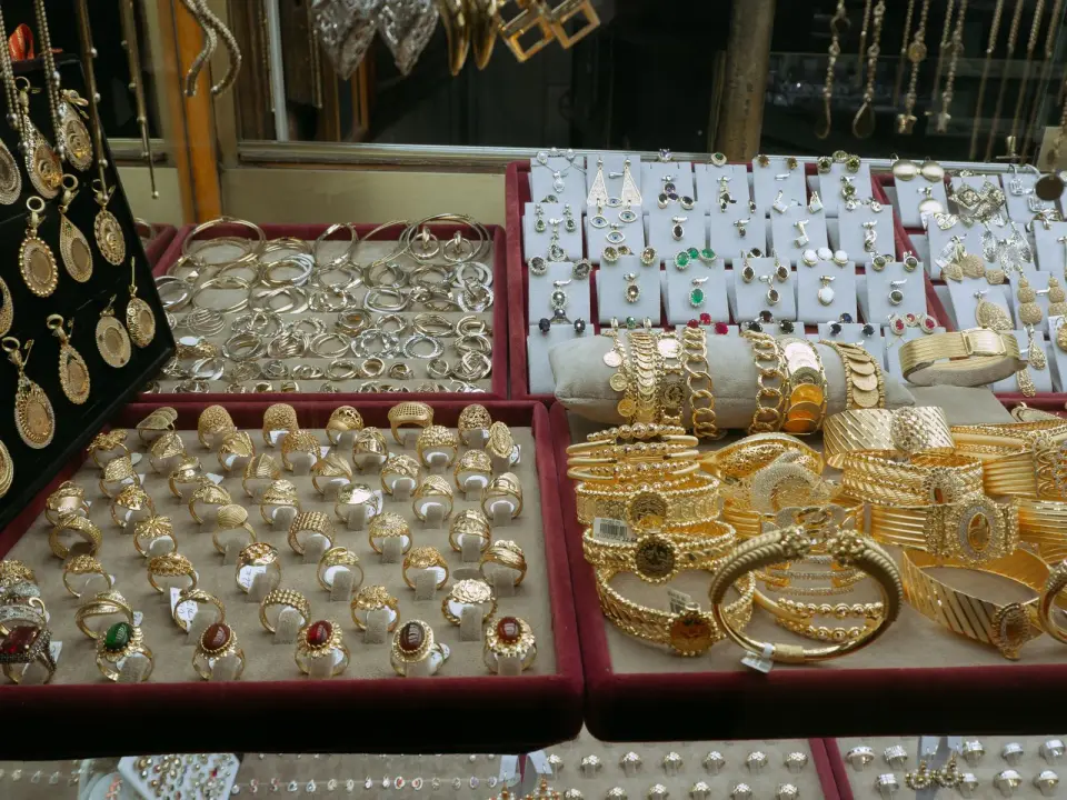 Gold rings, bangles and pendants in red velvet trays inside a market jewelry case