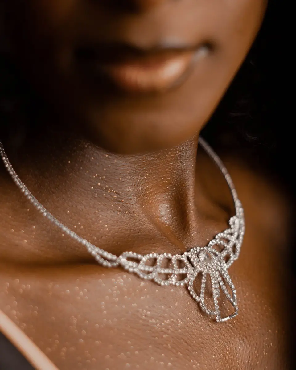 Diamond lace necklace on a woman’s collarbone, close-up in warm light