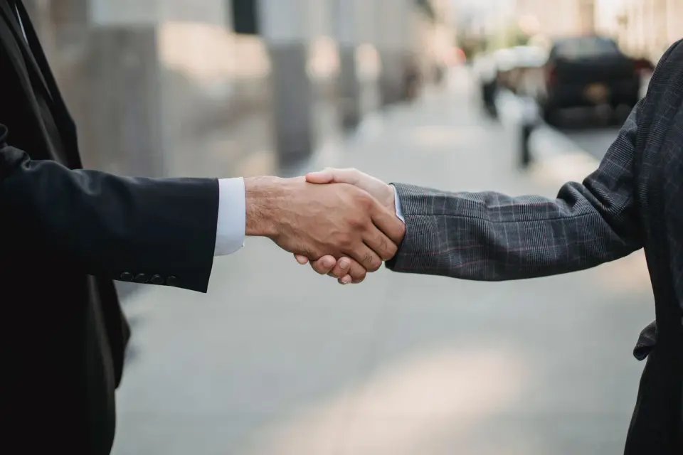 Close-up of two business partners in suits shaking hands