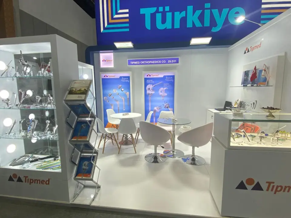 Tipmed Orthopaedics trade show booth by Purple Exhibits with lit glass cases of implants and instruments and a white seating area