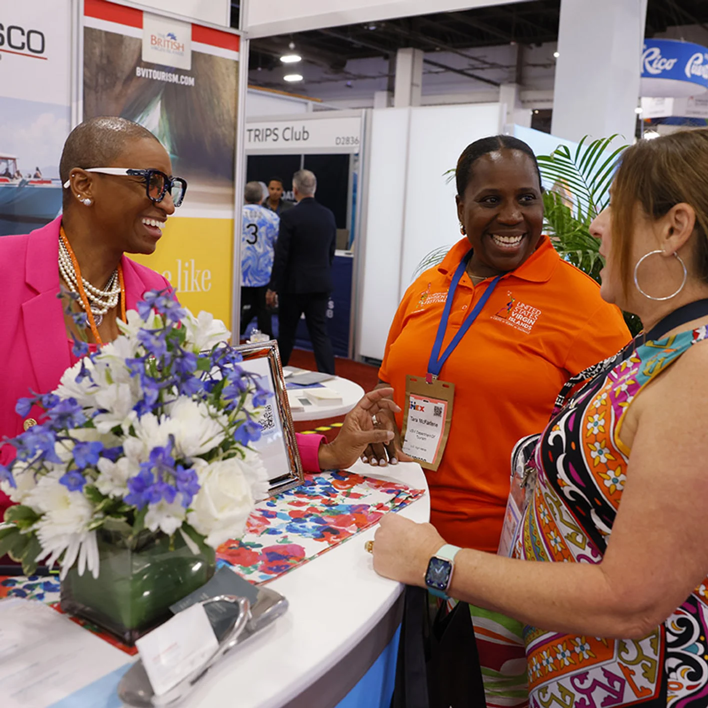 Women share a lively conversation at an exhibition booth at IMEX America.