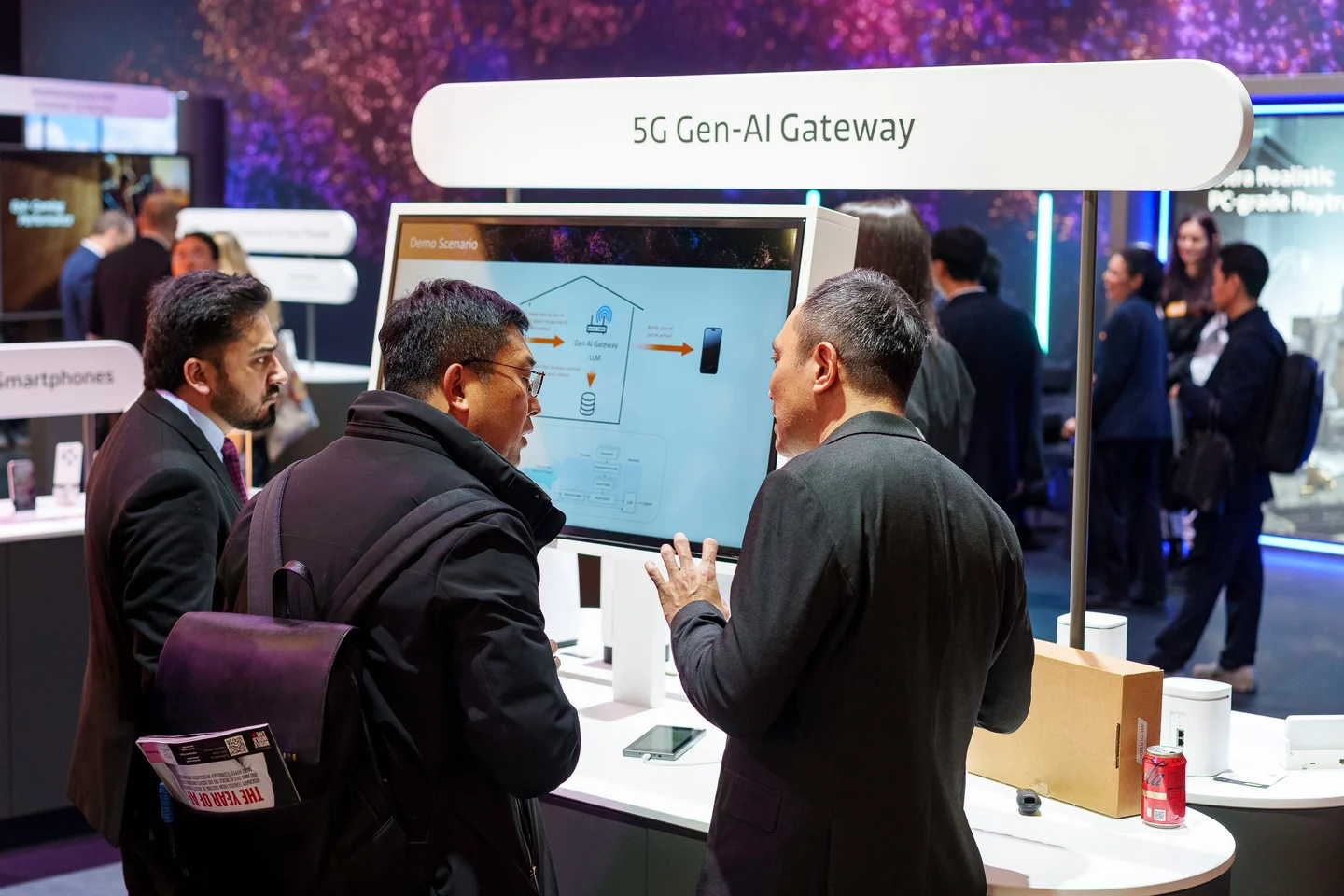 A MediaTek exhibitor guides two visitors through an on-screen demonstration at a purple-lit booth.