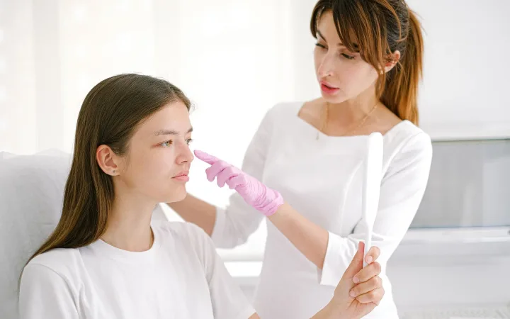 A woman receives a facial consultation from a cosmetologist.