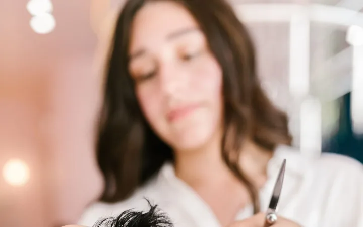 Professional hairstylist cutting a woman’s hair in a salon