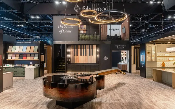 Fabuwood’s KBIS exhibit with a large guitar-shaped centerpiece, suspended ring lights, cabinetry room settings and an upper-level meeting area.