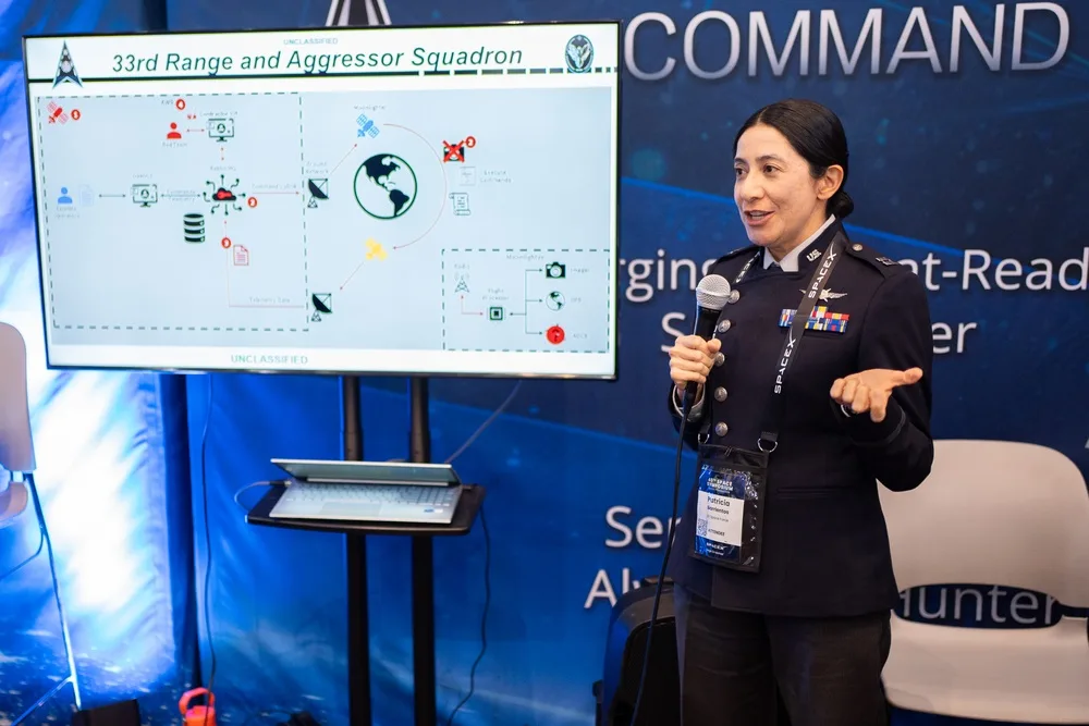 Capt. Patricia Barrientos briefs visitors at the STARCOM exhibit during the 40th Space Symposium.