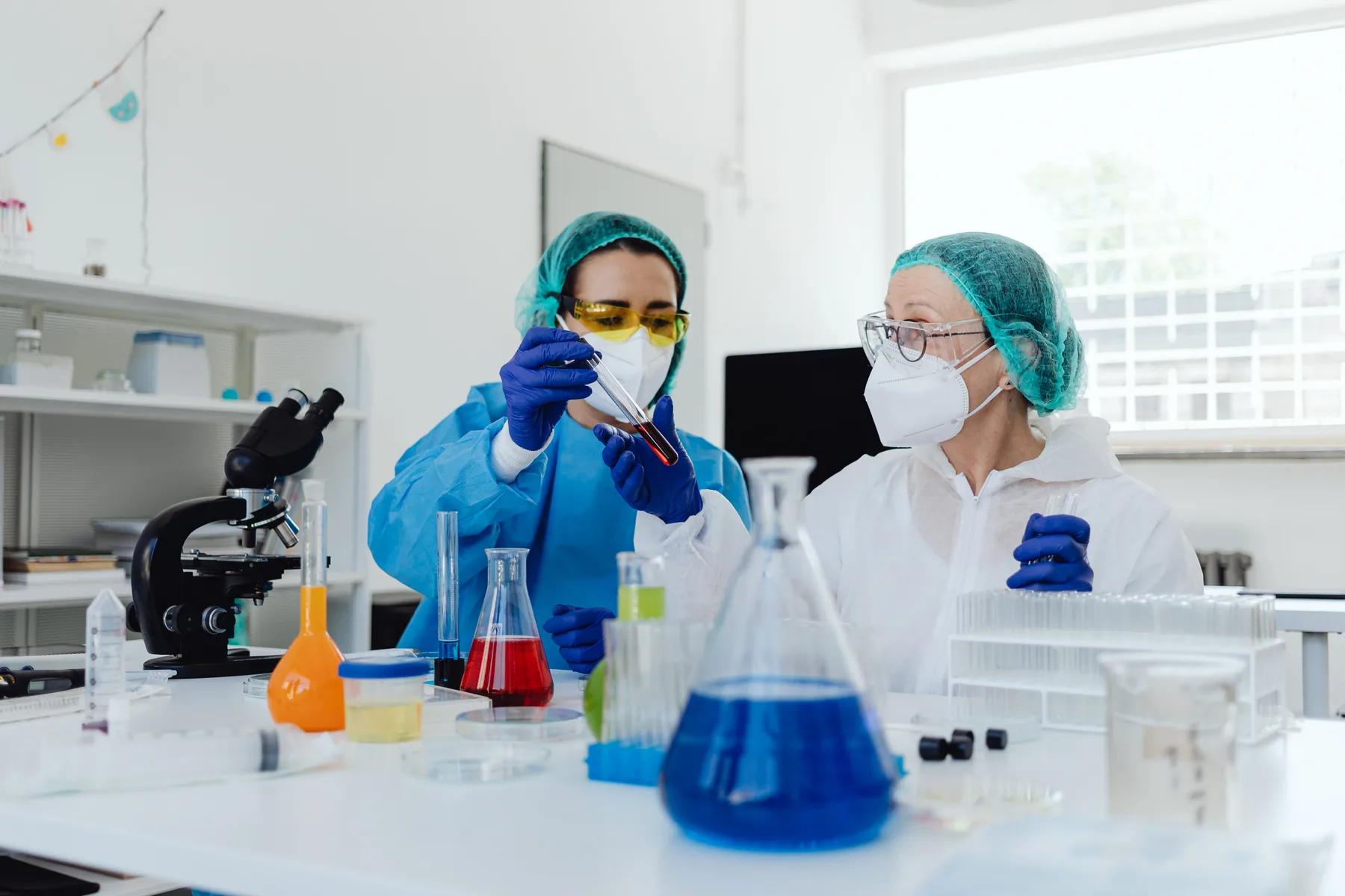 Two women work with samples in a laboratory.