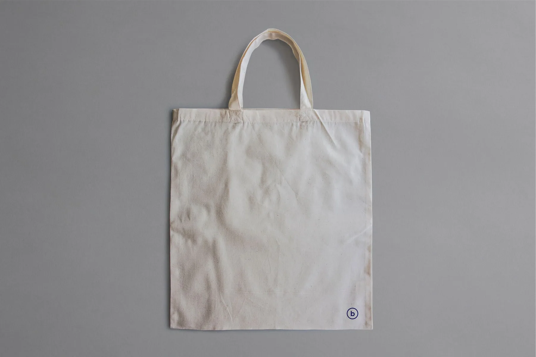 A plain canvas tote bag displayed against a neutral background.