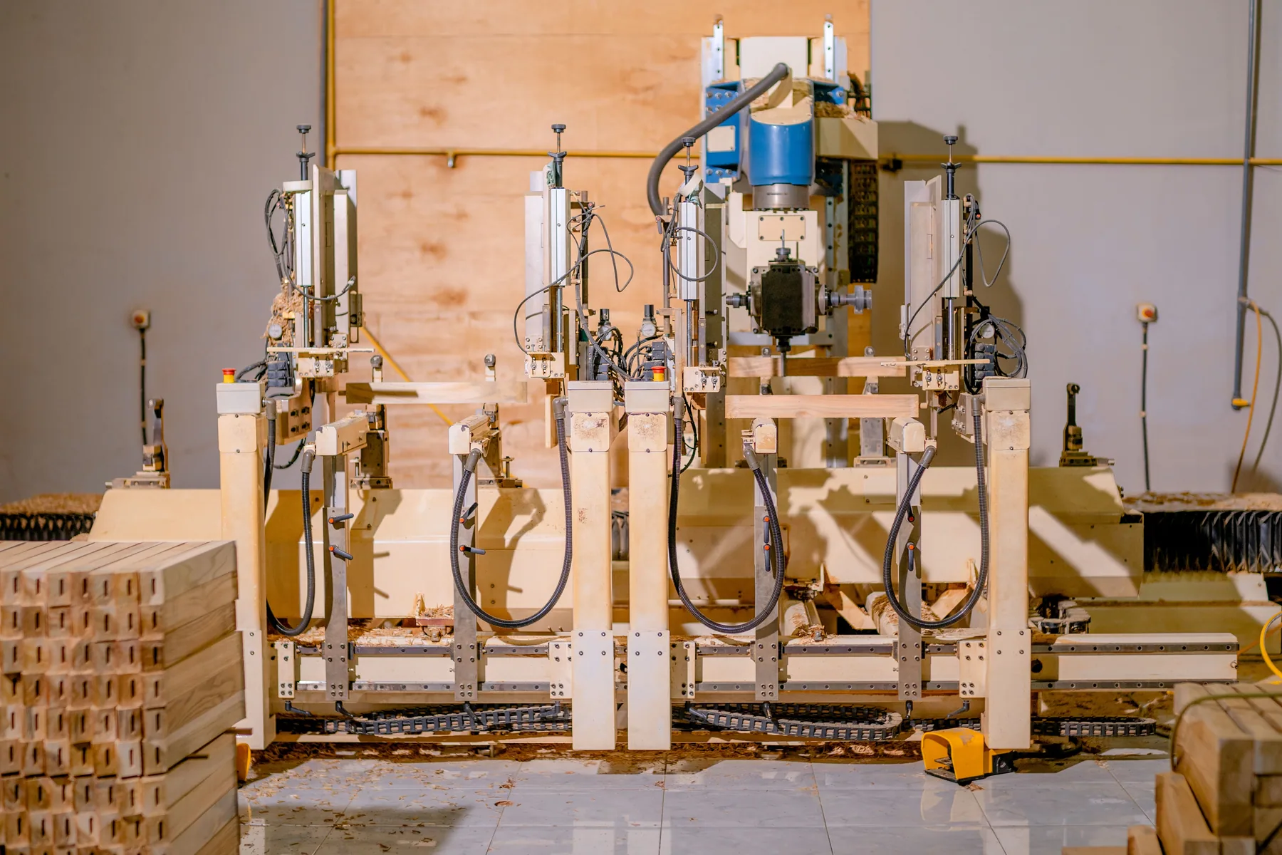 Woodworking machinery positioned over timber in a factory.
