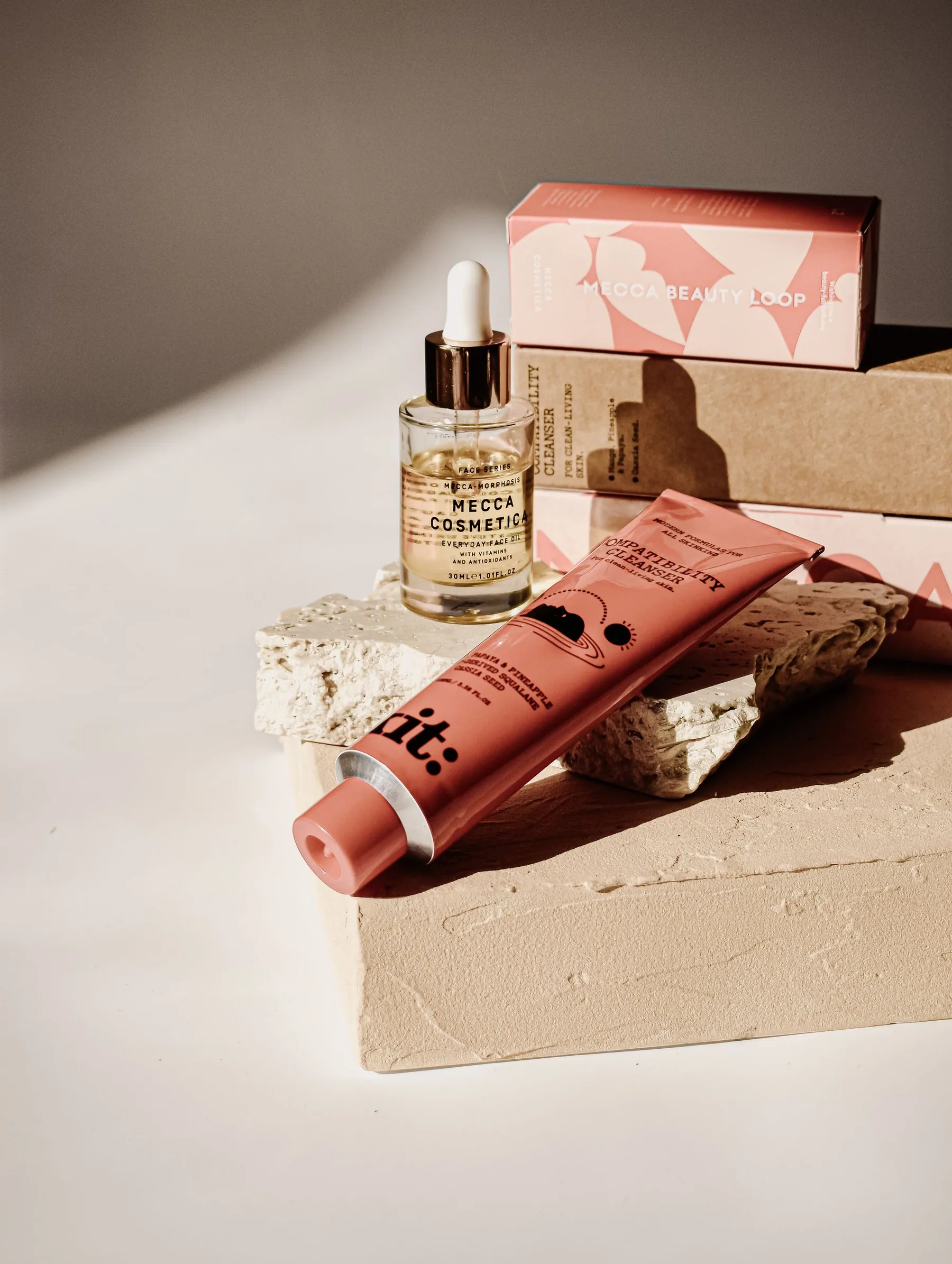 Skincare bottles and cosmetic containers arranged in warm sunlight.