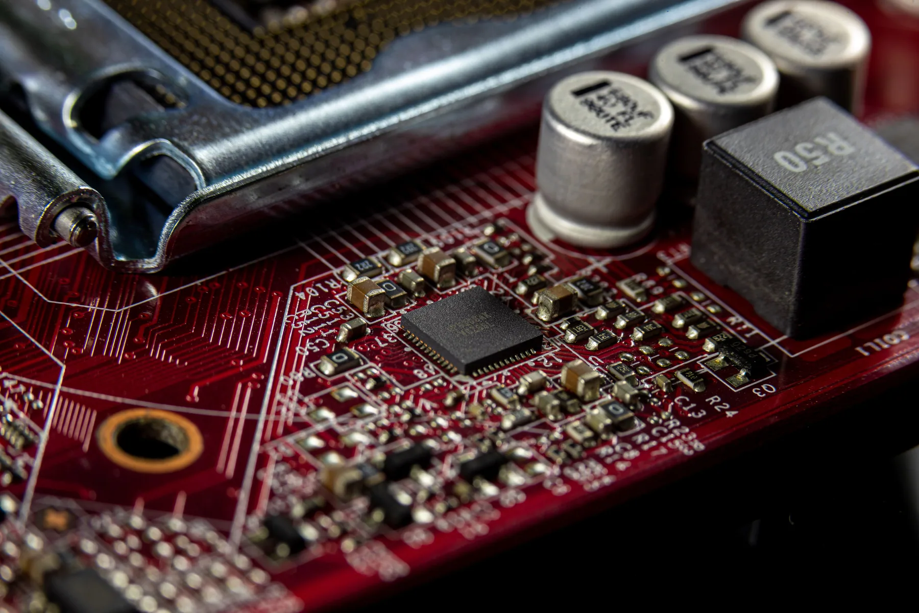 Close view of chips, capacitors and traces on a computer circuit board.