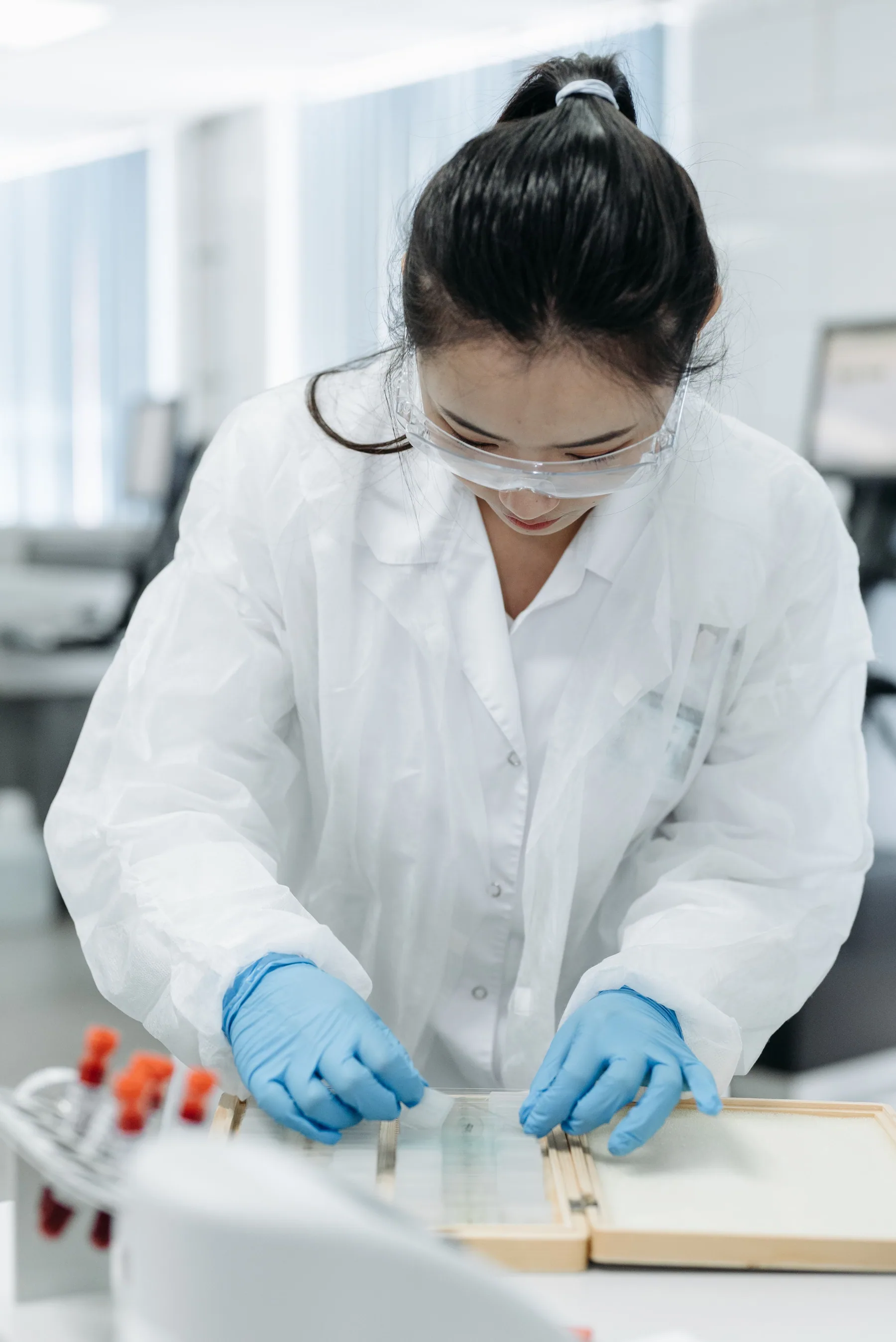A woman examines samples while working in a laboratory.