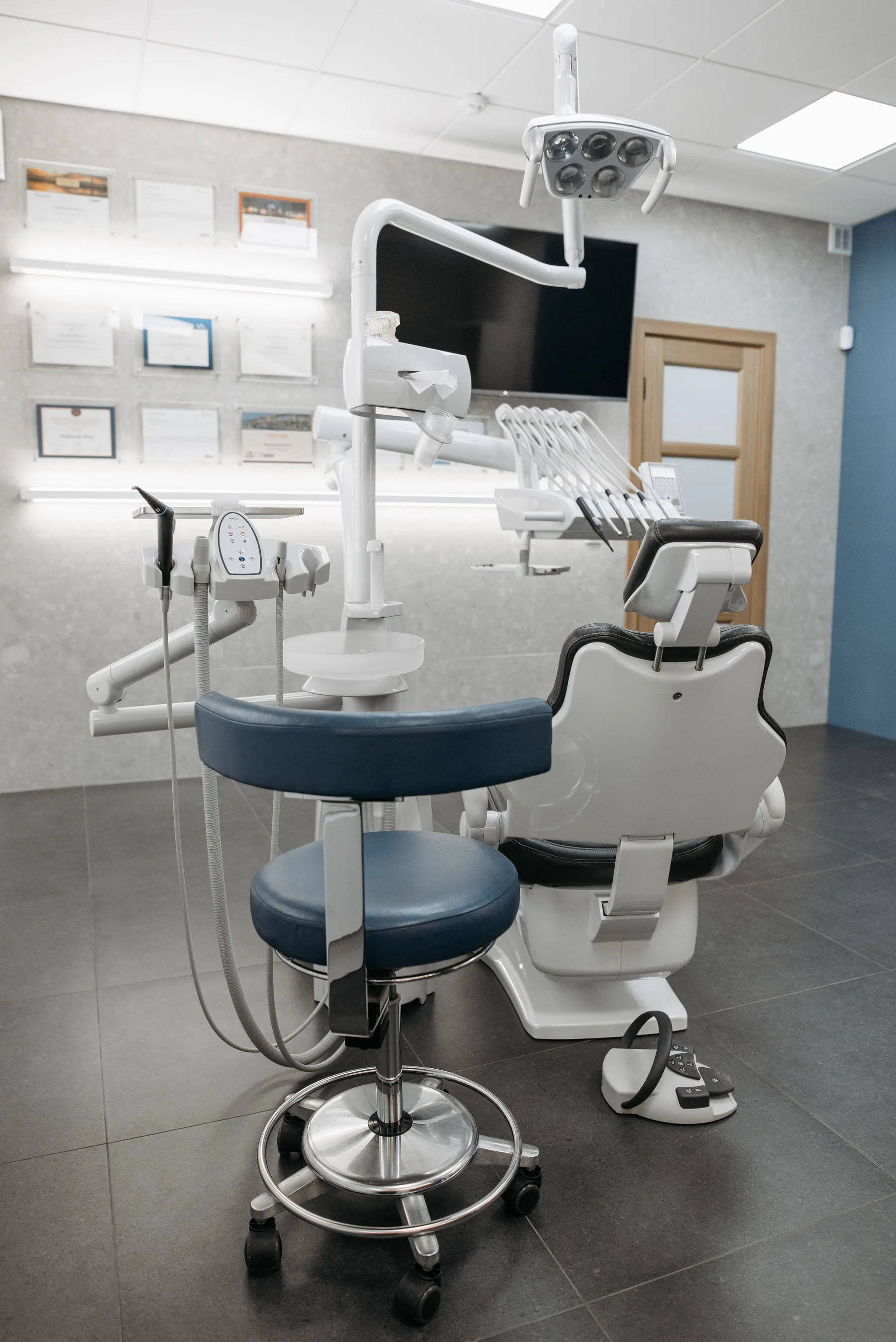 An empty dental office with a chair and modern equipment.