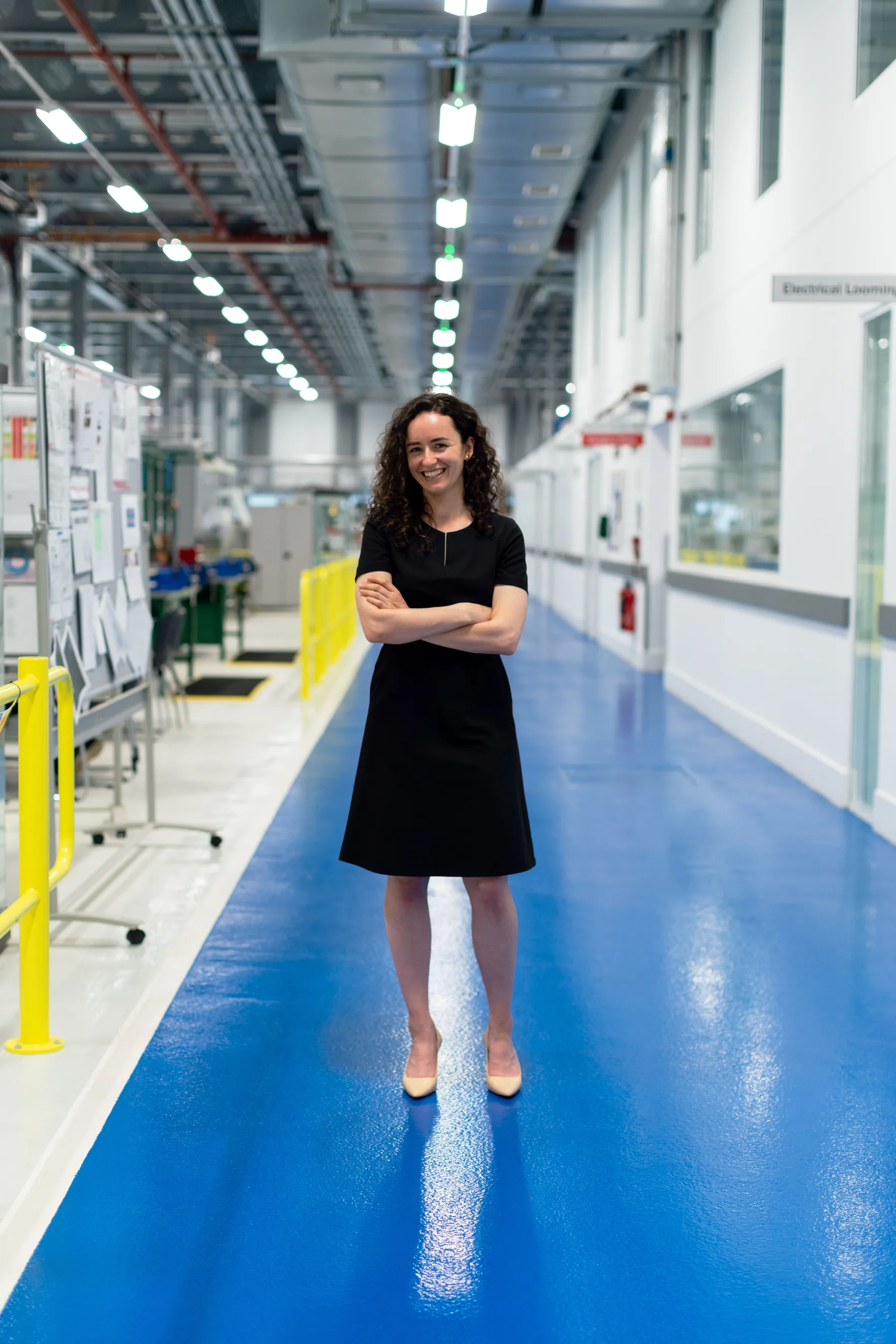 A woman engineer stands in an industrial engineering facility.