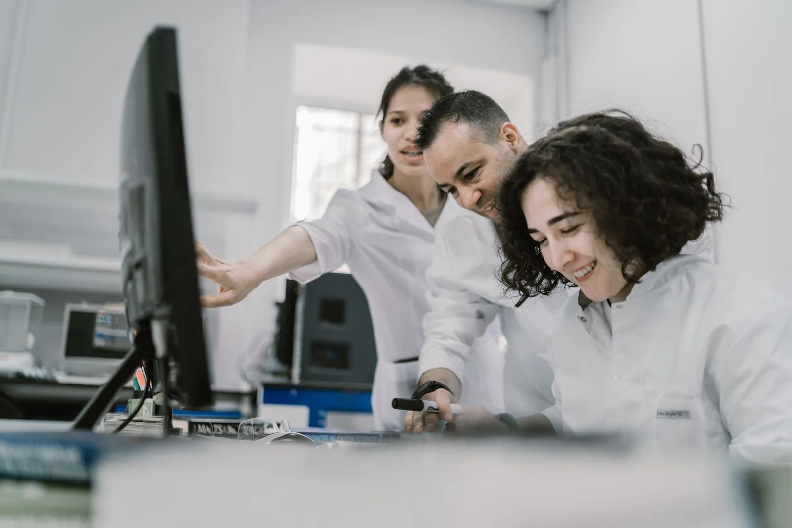 Scientists collaborating around a computer in a bright laboratory