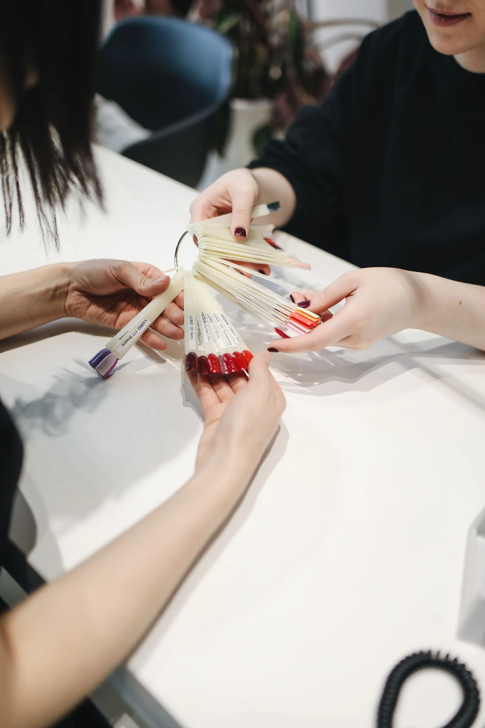 Customer and beauty professional comparing nail polish color samples