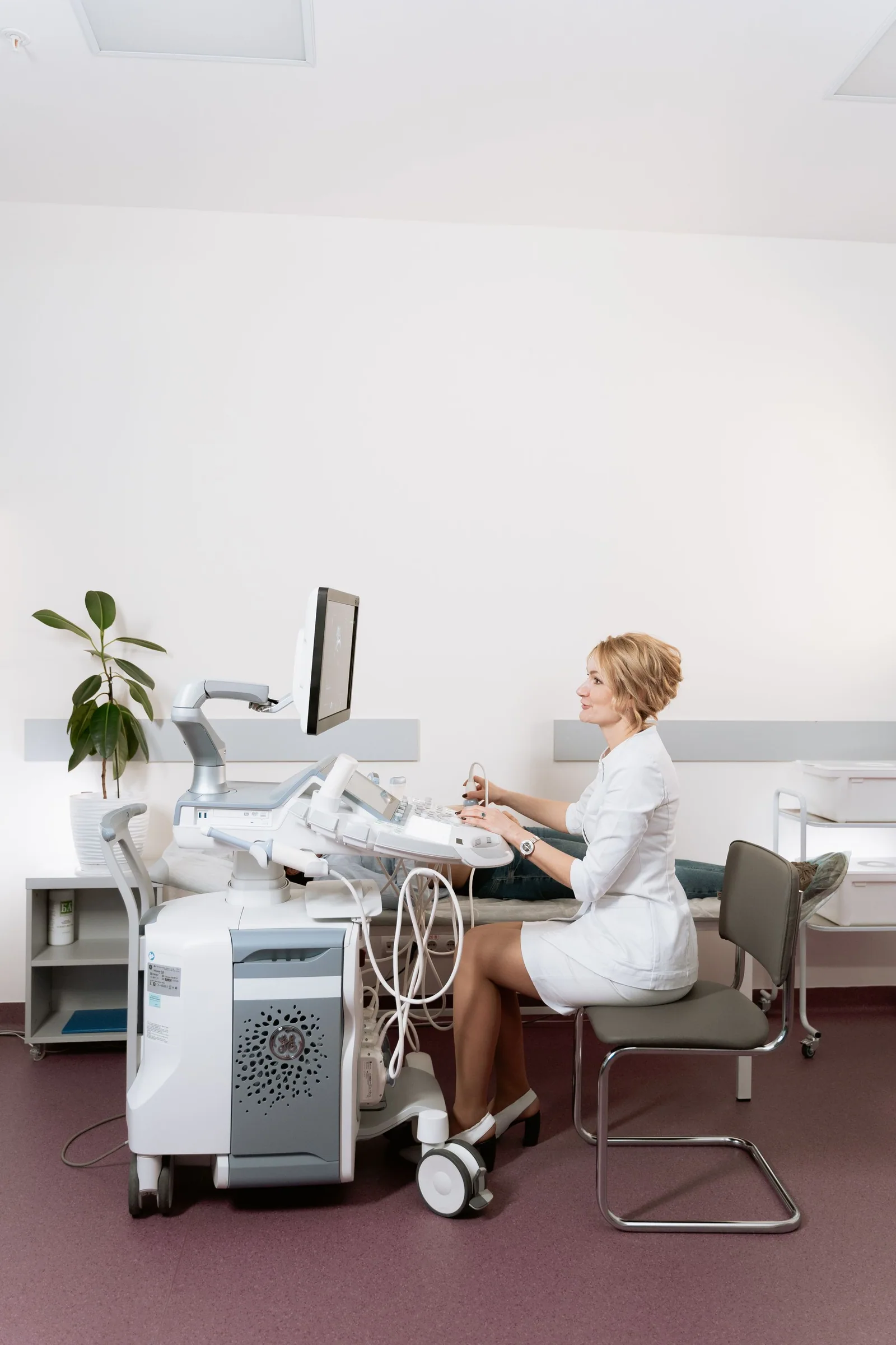 Woman operating an ultrasound machine in a medical clinic