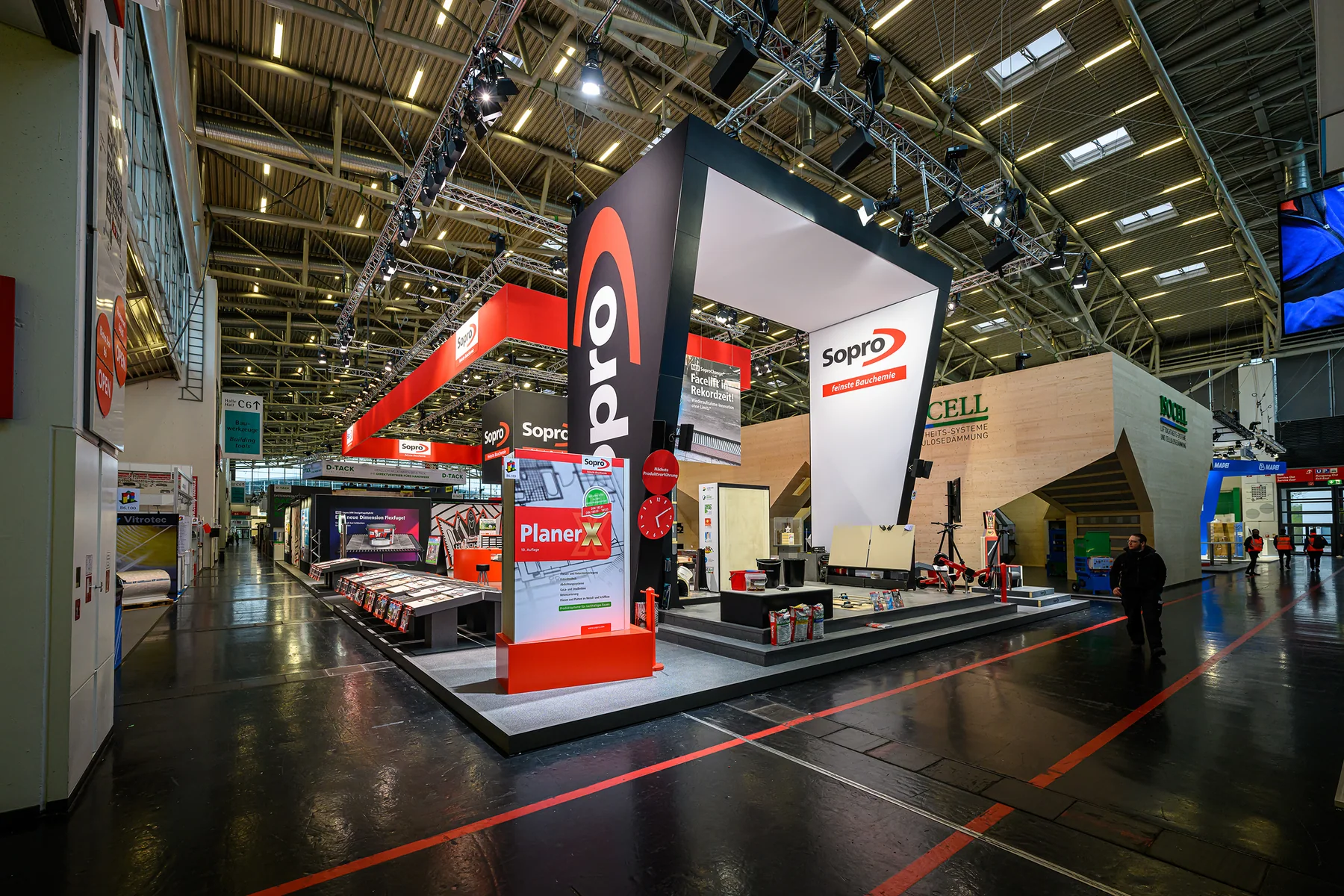Sopro's architectural exhibit at BAU 2023 with a large illuminated portal, building-material displays and open demonstration space.