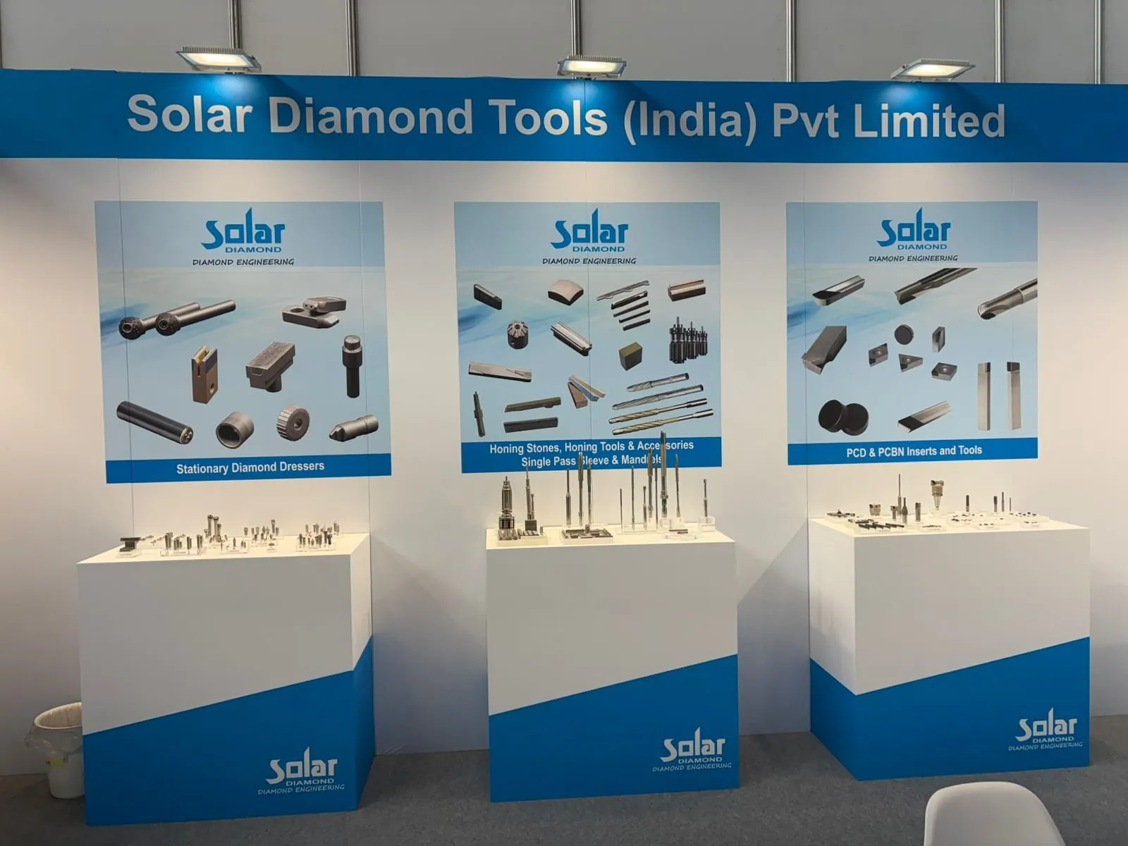 Three blue-and-white display plinths presenting precision tools beneath Solar Diamond Tools product diagrams.