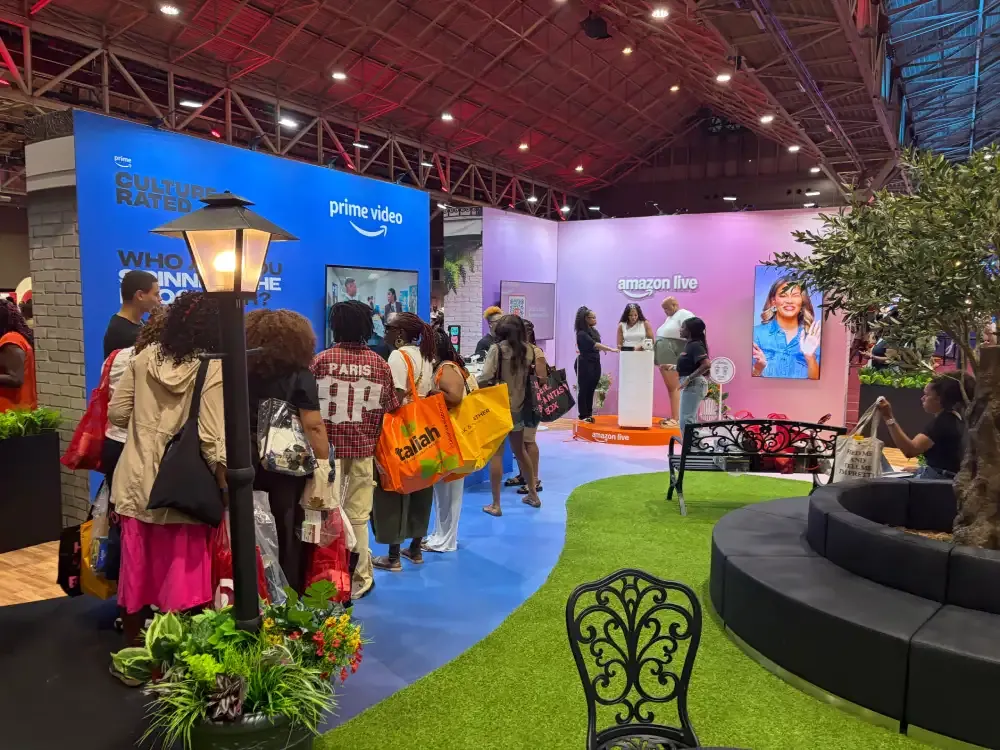 Visitors following a blue path through Amazon’s activation with Prime Video and Amazon Live walls, artificial turf, trees and curved seating.