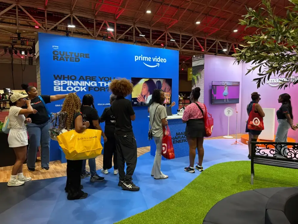 Visitors engaging with displays along Amazon’s blue Prime Video wall and purple Amazon Live zone.