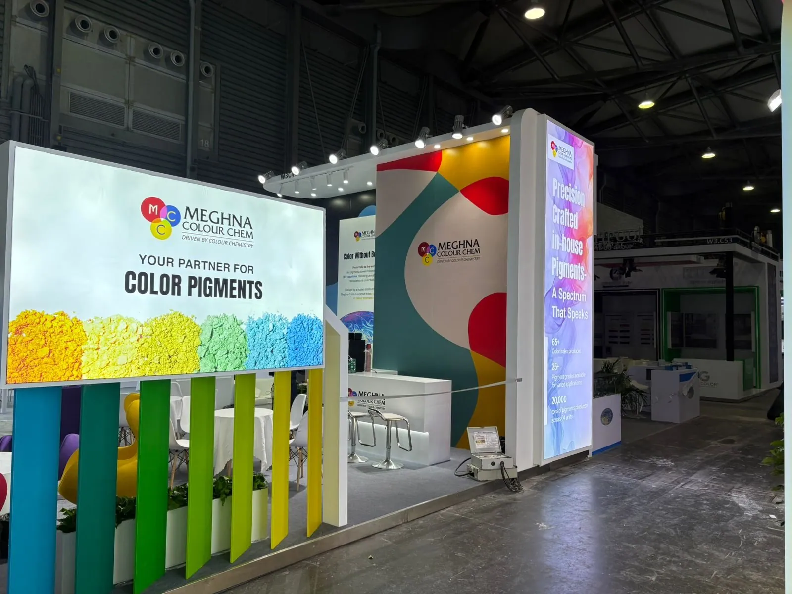 Meghna Colour Chem exhibit with an illuminated color-pigment graphic, vertical colored fins and a tall backlit branding tower.